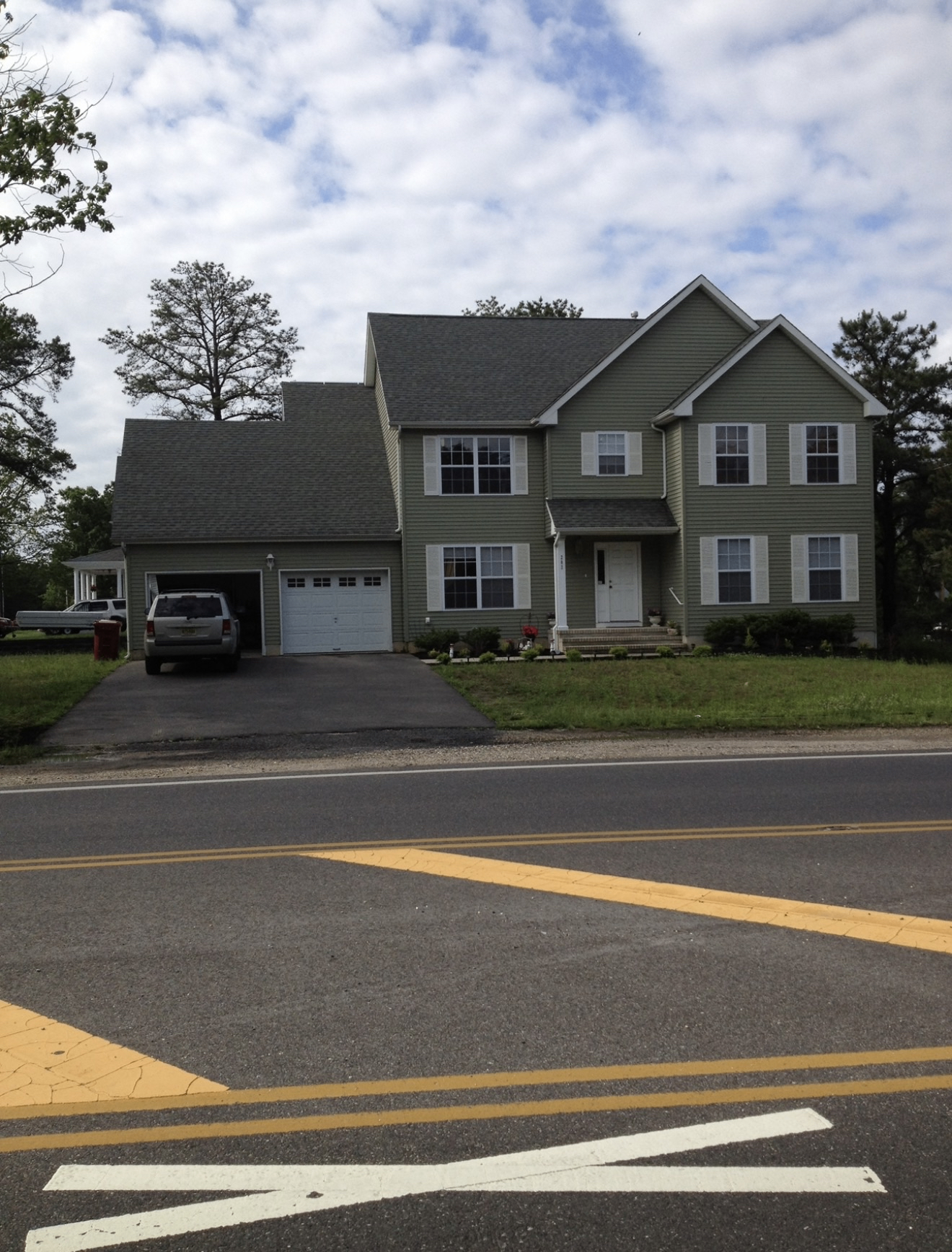 Two-story colonial home exterior with completed electrical service installation